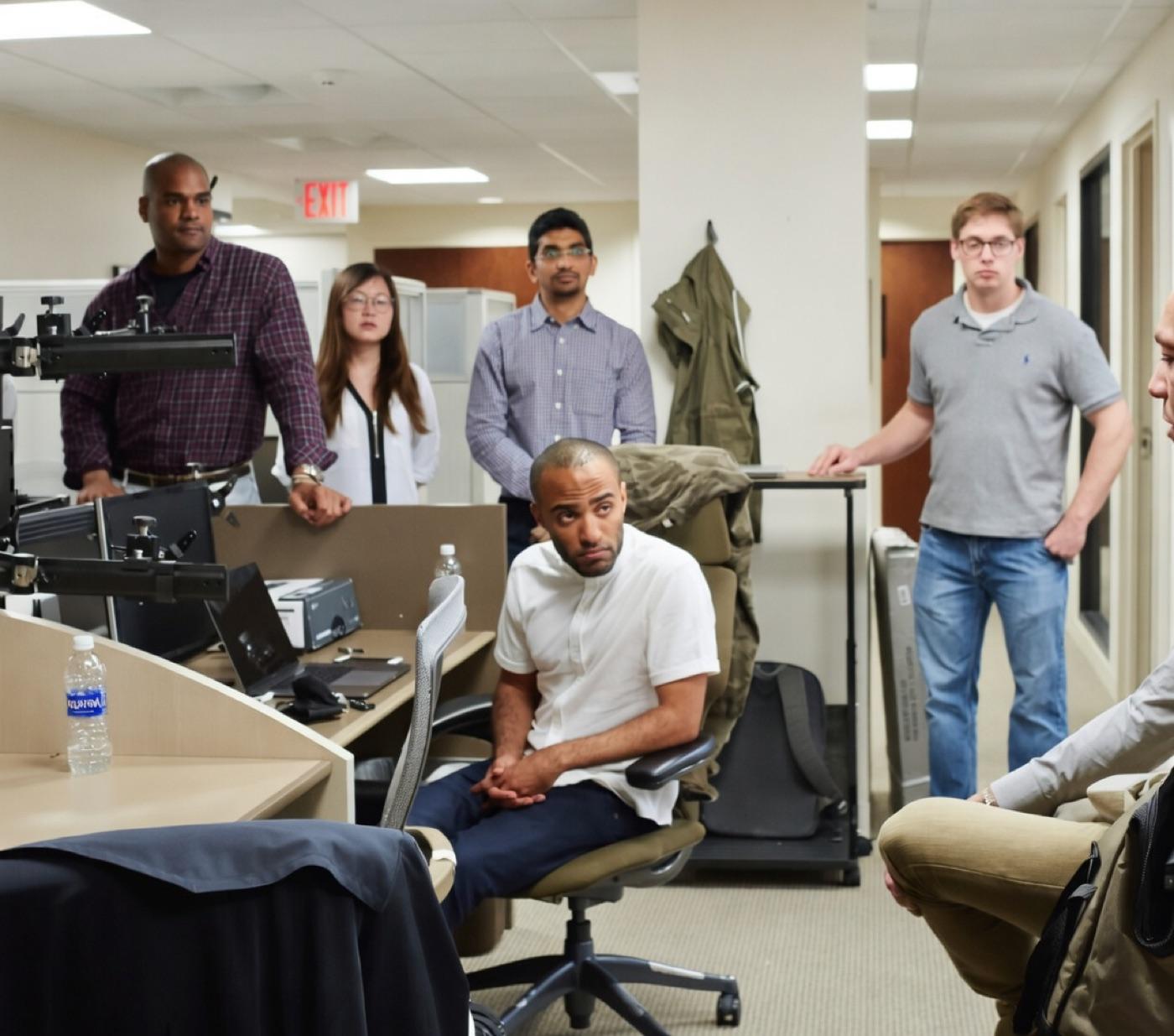 Jordan seated with a team gathered around him, working through a problem.