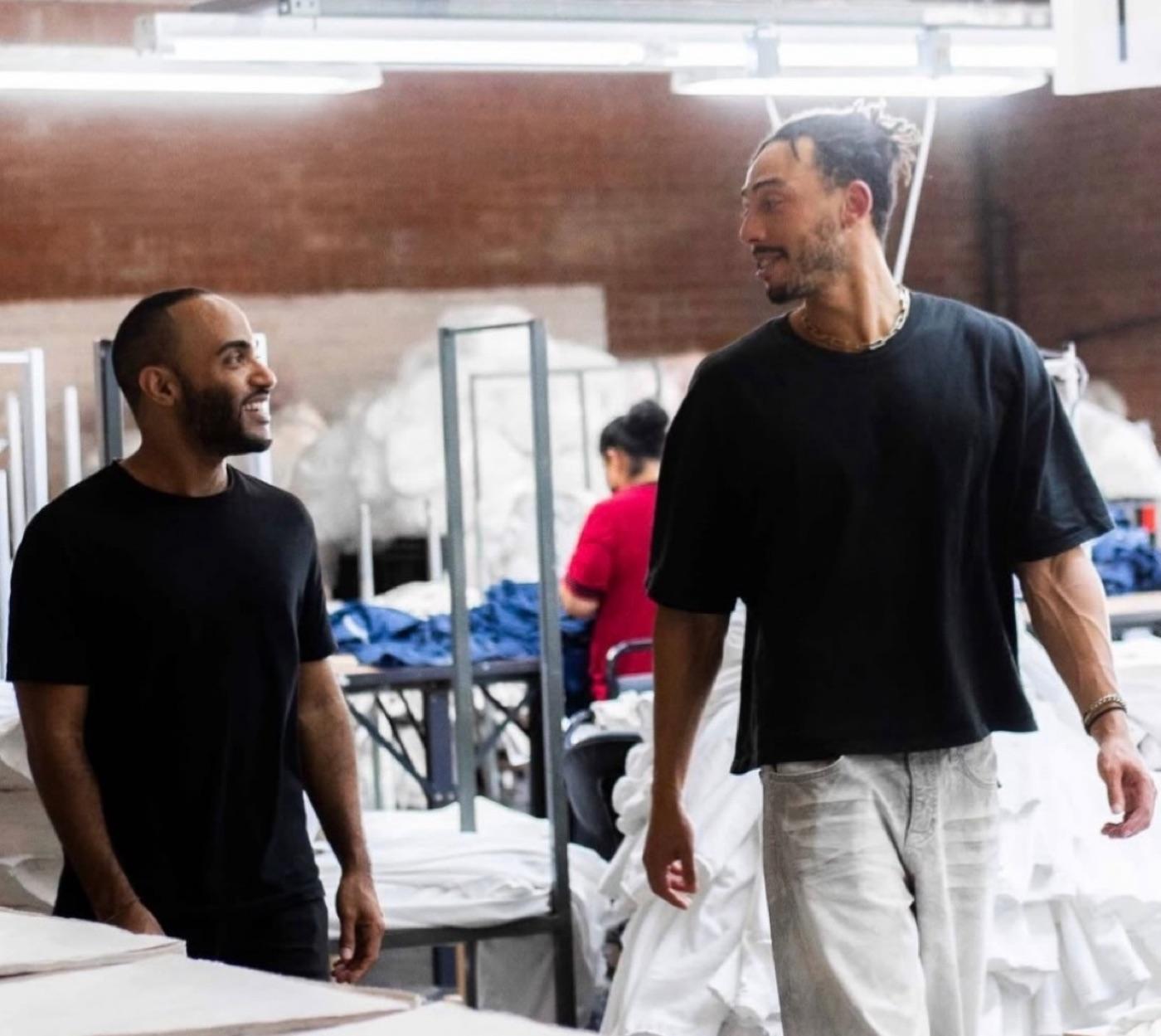 Jordan walking a garment production floor with a founder.